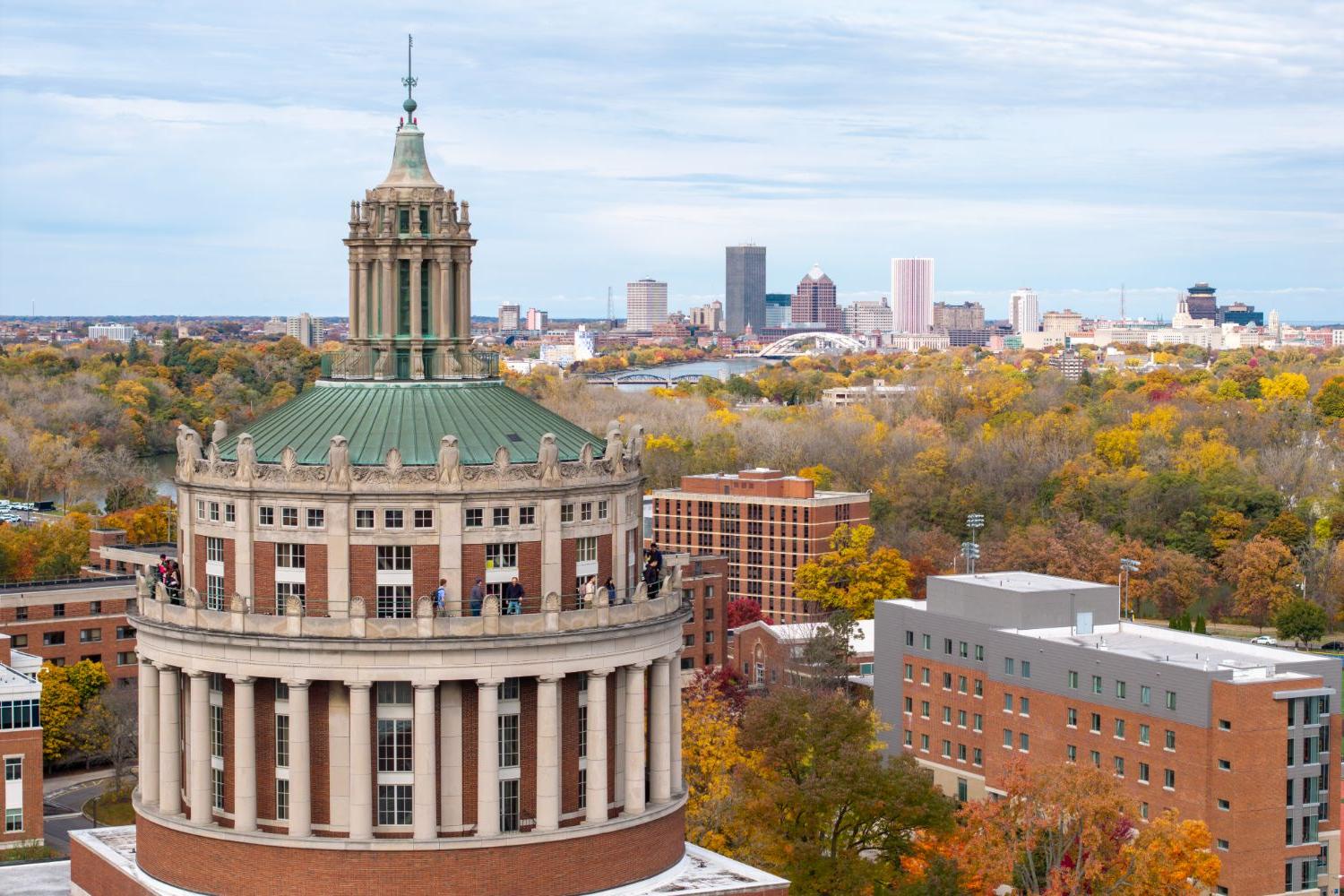 Aerial view of the University of Rochester, showcasing the cityscape and surrounding landscape from above.